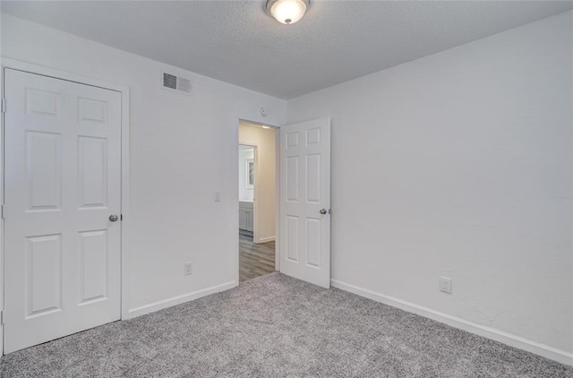 1409 Mcdonald Dr, Midwest City, OK 73130 - unfurnished bedroom featuring carpet and a textured ceiling