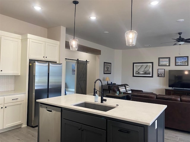 5557 Coker Rd, Shawnee, OK 74804 - kitchen featuring stainless steel appliances, open floor plan, light wood-style flooring, a barn door, and recessed lighting