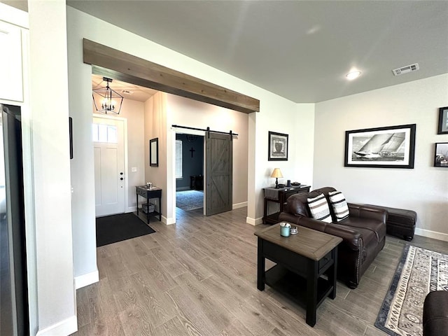 5557 Coker Rd, Shawnee, OK 74804 - living room with a barn door, light wood-style flooring, and a chandelier