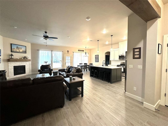 5557 Coker Rd, Shawnee, OK 74804 - living room with a ceiling fan, light wood-style floors, a stone fireplace, recessed lighting, and arched walkways