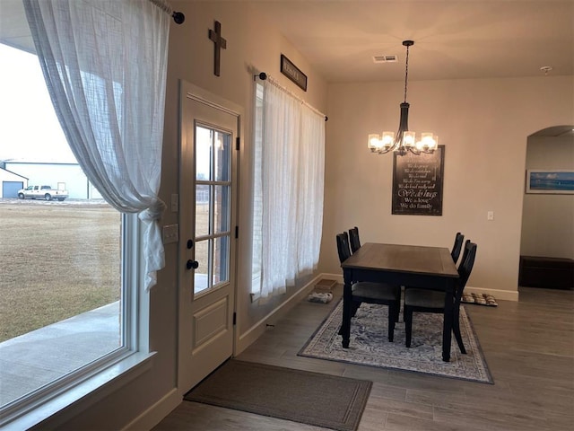 5557 Coker Rd, Shawnee, OK 74804 - dining area featuring a chandelier, wood finished floors, and arched walkways