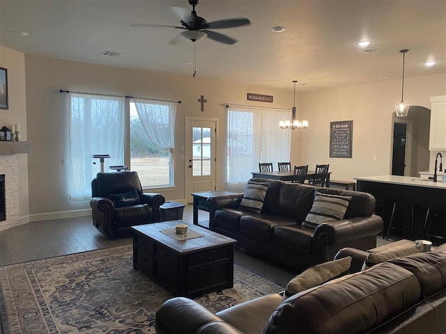 5557 Coker Rd, Shawnee, OK 74804 - living room featuring a ceiling fan, dark wood-type flooring, a chandelier, a fireplace, and recessed lighting