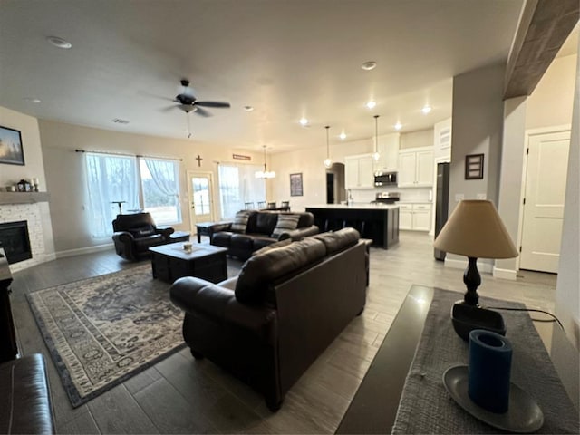 5557 Coker Rd, Shawnee, OK 74804 - living room with ceiling fan, wood finished floors, recessed lighting, and a stone fireplace