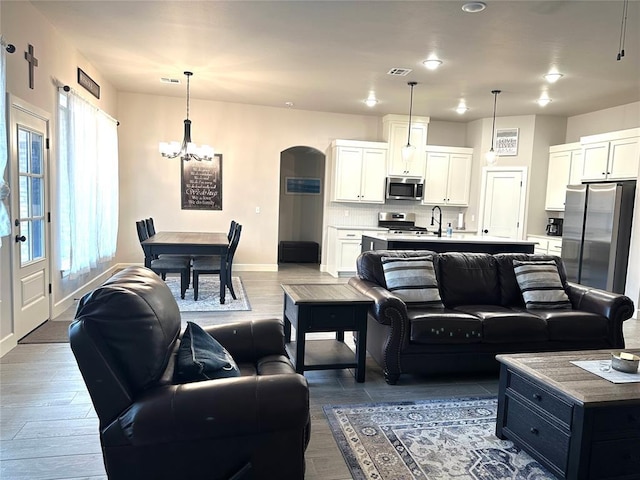 5557 Coker Rd, Shawnee, OK 74804 - living room with a chandelier, dark wood finished floors, and arched walkways