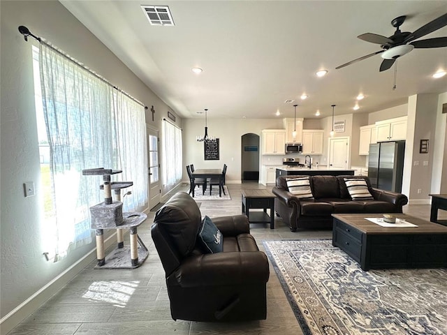 5557 Coker Rd, Shawnee, OK 74804 - living room with ceiling fan, recessed lighting, arched walkways, and wood finished floors