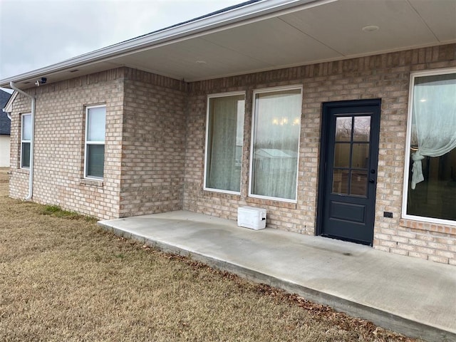5557 Coker Rd, Shawnee, OK 74804 - view of exterior entry featuring brick siding and a patio