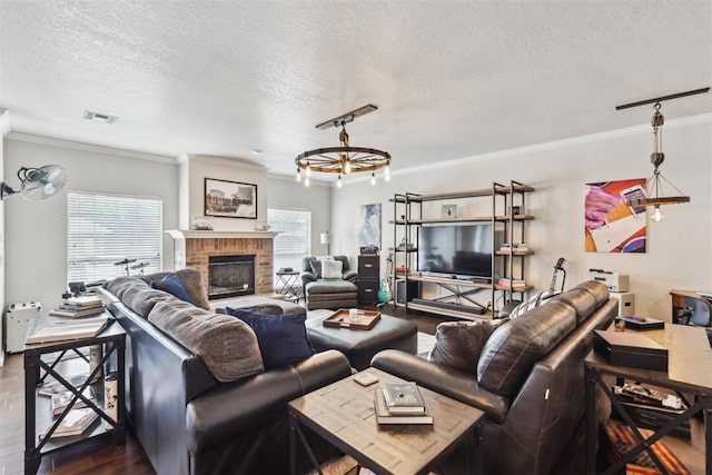 1800 NW 161st Pl, Edmond, OK 73013 - living room featuring dark wood finished floors, crown molding, a textured ceiling, and a fireplace