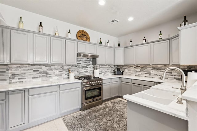 1800 NW 161st Pl, Edmond, OK 73013 - kitchen featuring high end stove, gray cabinetry, tasteful backsplash, under cabinet range hood, and recessed lighting