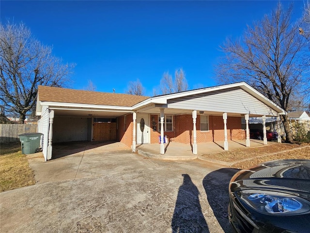 1137 Mallard Dr, Del City, OK 73115 - ranch-style home featuring concrete driveway, covered porch, an attached carport, and brick siding