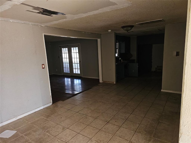 1137 Mallard Dr, Del City, OK 73115 - tiled spare room featuring french doors and a textured ceiling
