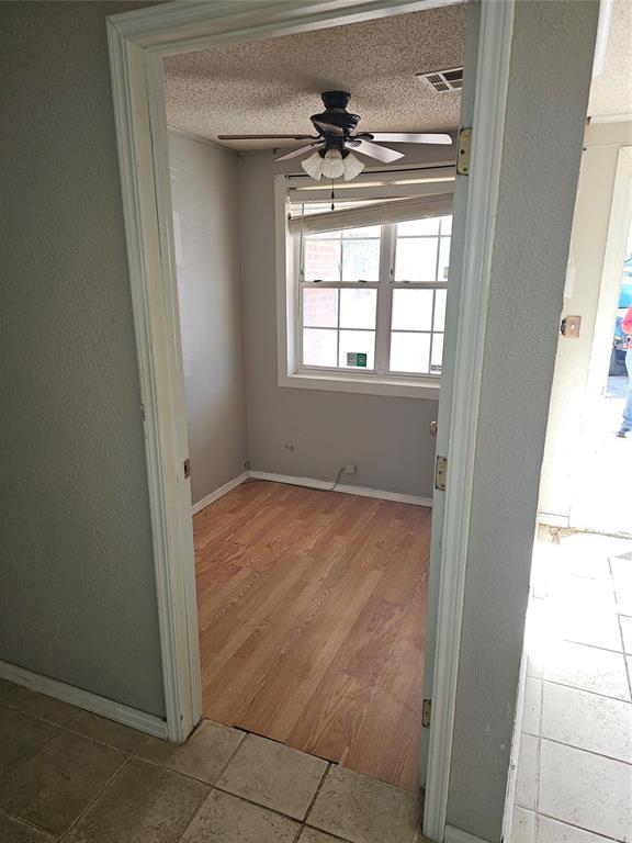 1137 Mallard Dr, Del City, OK 73115 - tiled empty room featuring a ceiling fan and a textured ceiling