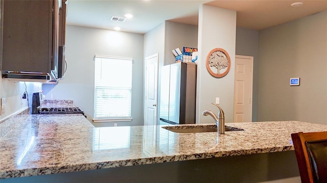 1016 NW 4th St, Newcastle, OK 73065 - kitchen with freestanding refrigerator, stove, light stone countertops, and recessed lighting