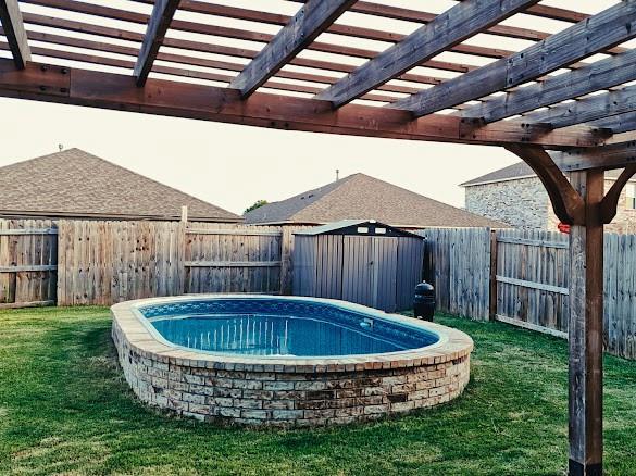 1016 NW 4th St, Newcastle, OK 73065 - view of swimming pool with a storage shed, a fenced backyard, and a pergola