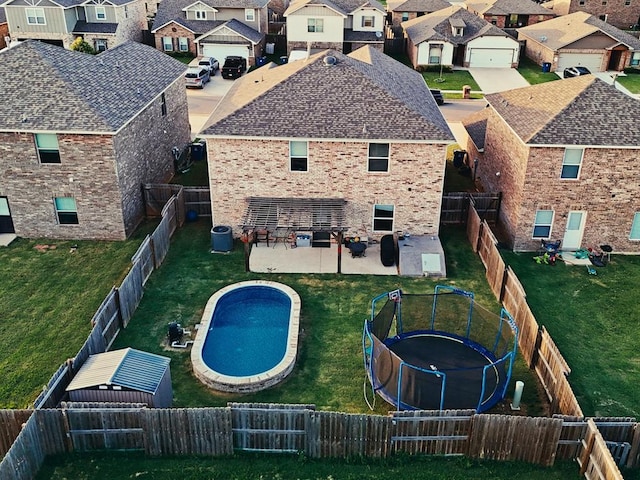 1016 NW 4th St, Newcastle, OK 73065 - back of property with a residential view, a trampoline, and a lawn