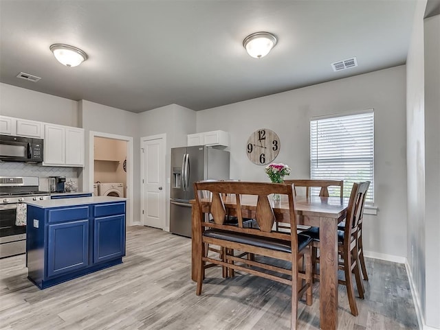 14325 Meadow Ridge Ln, Edmond, OK 73025 - dining space with washing machine and clothes dryer and light wood-style flooring
