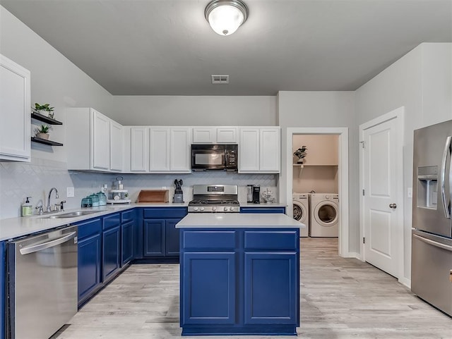 14325 Meadow Ridge Ln, Edmond, OK 73025 - kitchen with appliances with stainless steel finishes, washer and dryer, blue cabinetry, and light countertops