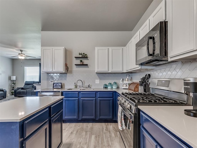 14325 Meadow Ridge Ln, Edmond, OK 73025 - kitchen featuring stainless steel appliances, blue cabinets, ceiling fan, and light countertops