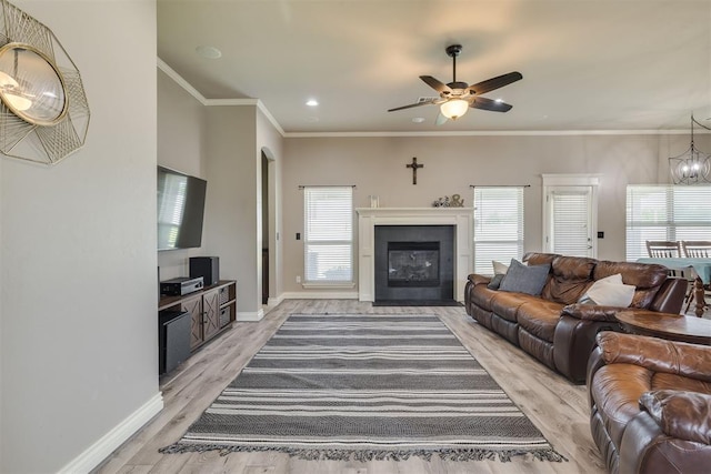 4501 NW 164th Ter, Edmond, OK 73013 - living area with light wood-style flooring, ceiling fan, a fireplace with flush hearth, crown molding, and recessed lighting