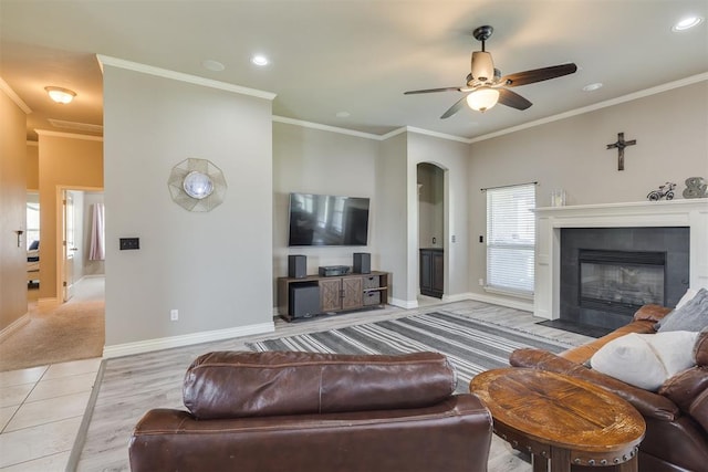 4501 NW 164th Ter, Edmond, OK 73013 - living area with light wood-style floors, arched walkways, ceiling fan, a fireplace, and ornamental molding