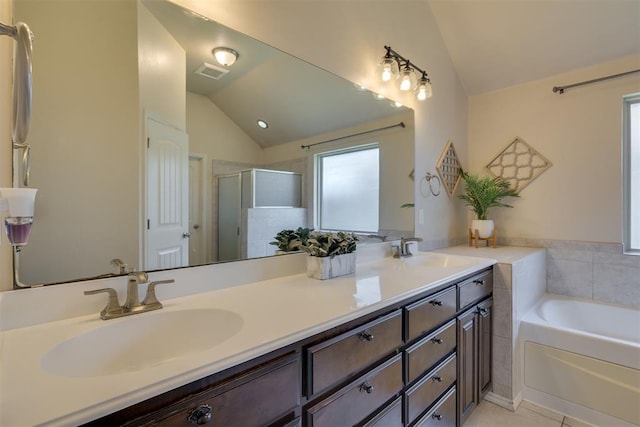 4501 NW 164th Ter, Edmond, OK 73013 - full bathroom featuring lofted ceiling, double vanity, a garden tub, a shower stall, and tile patterned flooring