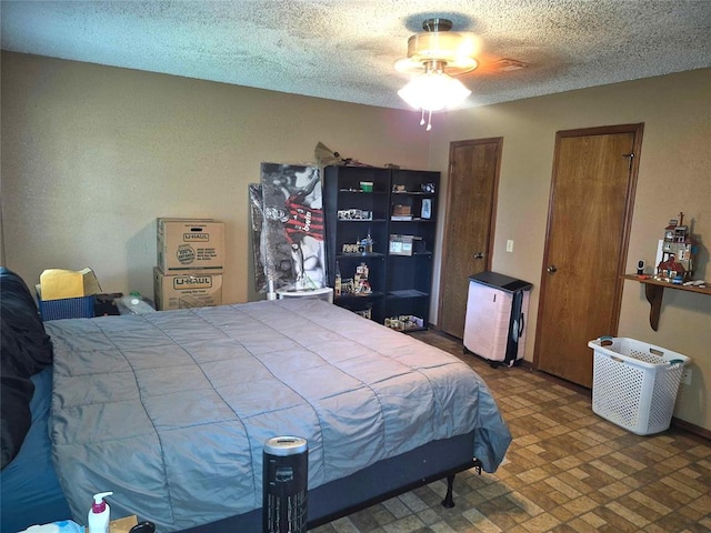 3120 Del Rey Dr, Midwest City, OK 73110 - bedroom featuring a textured ceiling, two closets, and brick patterned floors
