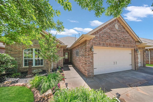 1840 Kamber Ter, Edmond, OK 73003 - view of front of home featuring brick siding, a garage, roof with shingles, and concrete driveway