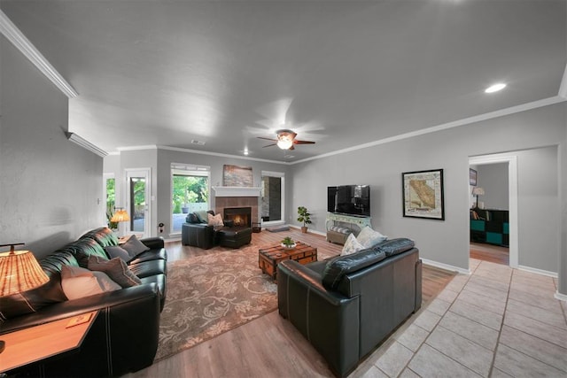 1840 Kamber Ter, Edmond, OK 73003 - living room with ceiling fan, ornamental molding, a tile fireplace, light wood finished floors, and recessed lighting