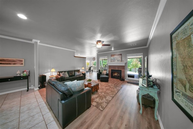 1840 Kamber Ter, Edmond, OK 73003 - living area featuring ceiling fan, crown molding, a tile fireplace, and light wood-style flooring