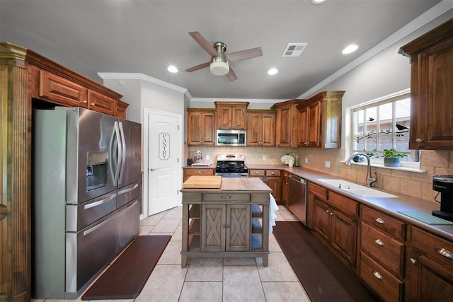 1840 Kamber Ter, Edmond, OK 73003 - kitchen featuring appliances with stainless steel finishes, ornamental molding, a ceiling fan, decorative backsplash, and light tile patterned floors