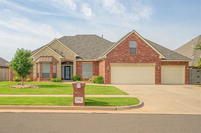 5404 NW 119th St, Oklahoma City, OK 73162 - view of front facade featuring concrete driveway, roof with shingles, brick siding, and an attached garage