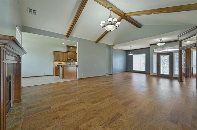 5404 NW 119th St, Oklahoma City, OK 73162 - unfurnished living room featuring a fireplace, a chandelier, light wood-style floors, beamed ceiling, and high vaulted ceiling
