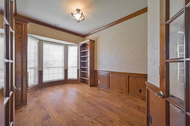 5404 NW 119th St, Oklahoma City, OK 73162 - spare room featuring ornamental molding, wood finished floors, a wainscoted wall, and a textured wall
