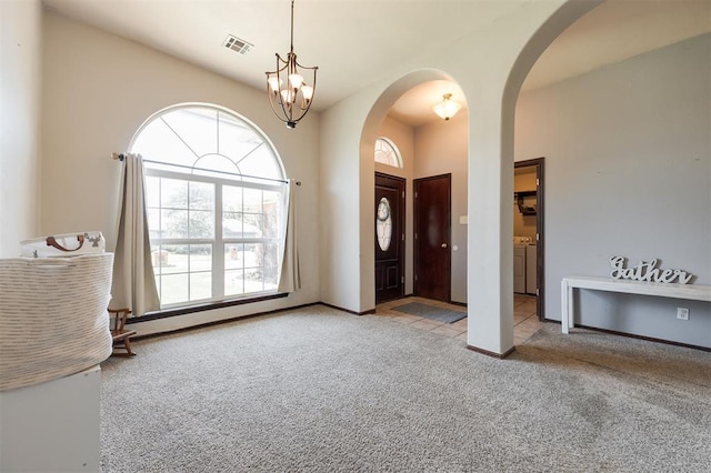 2001 Fair Meadow Dr, Edmond, OK 73003 - carpeted entryway featuring arched walkways, separate washer and dryer, and healthy amount of natural light
