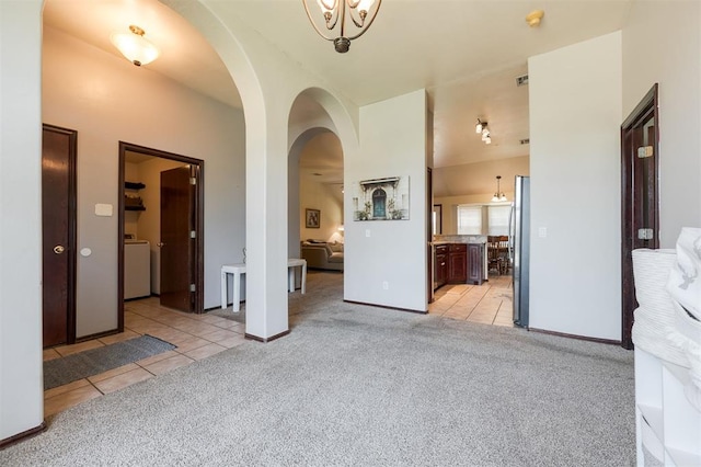 2001 Fair Meadow Dr, Edmond, OK 73003 - bedroom featuring light colored carpet, freestanding refrigerator, washer / clothes dryer, arched walkways, and light tile patterned floors