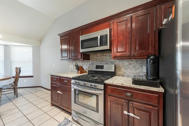2001 Fair Meadow Dr, Edmond, OK 73003 - kitchen featuring appliances with stainless steel finishes, lofted ceiling, backsplash, light tile patterned floors, and light stone counters