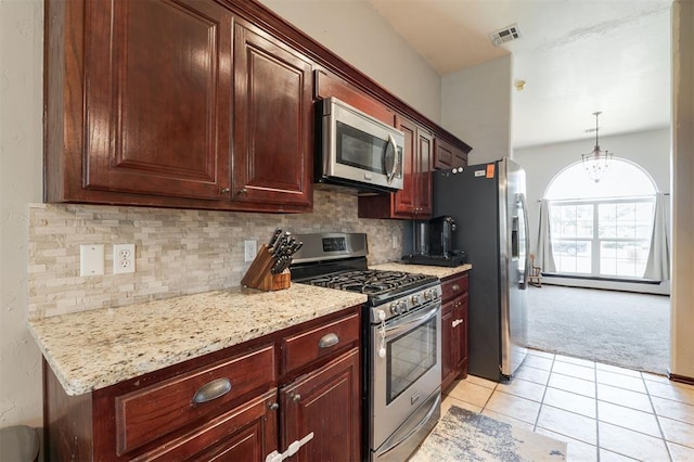 2001 Fair Meadow Dr, Edmond, OK 73003 - kitchen with appliances with stainless steel finishes, light carpet, light tile patterned floors, tasteful backsplash, and light stone counters