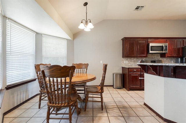 2001 Fair Meadow Dr, Edmond, OK 73003 - dining room featuring vaulted ceiling, light tile patterned flooring, and a chandelier