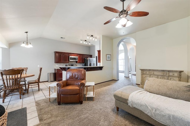 2001 Fair Meadow Dr, Edmond, OK 73003 - living area with arched walkways, vaulted ceiling, a ceiling fan, and light tile patterned floors