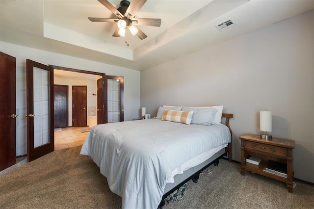 2001 Fair Meadow Dr, Edmond, OK 73003 - bedroom with french doors, carpet flooring, a raised ceiling, ensuite bath, and a ceiling fan