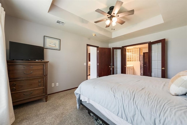 2001 Fair Meadow Dr, Edmond, OK 73003 - carpeted bedroom featuring a raised ceiling, ensuite bathroom, and ceiling fan
