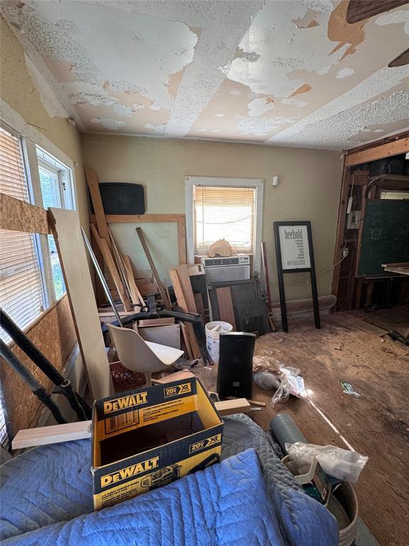 2701 NW 12th St, Oklahoma City, OK 73107 - bedroom featuring multiple windows, cooling unit, and a textured ceiling