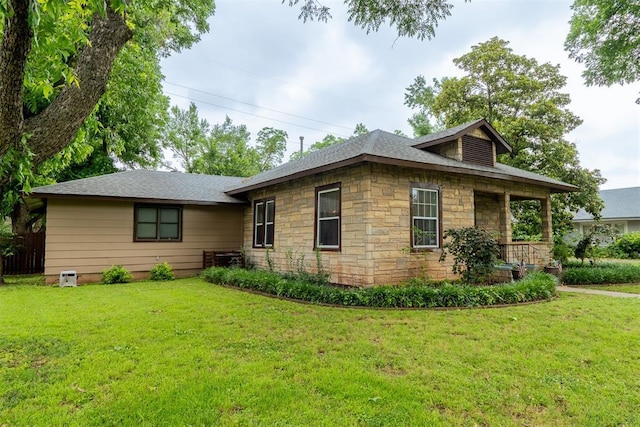 828 N Pine St, Pauls Valley, OK 73075 - view of front of house with stone siding, a front lawn, and a shingled roof