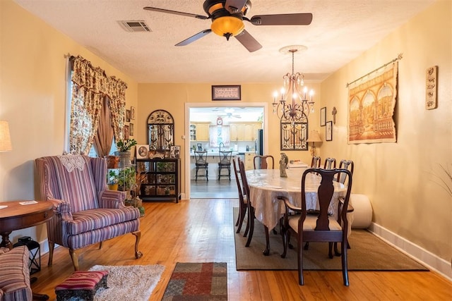 828 N Pine St, Pauls Valley, OK 73075 - dining area featuring wood finished floors, ceiling fan, a chandelier, and a textured ceiling