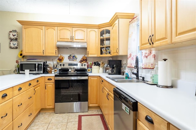 828 N Pine St, Pauls Valley, OK 73075 - kitchen featuring appliances with stainless steel finishes, under cabinet range hood, light brown cabinets, and backsplash