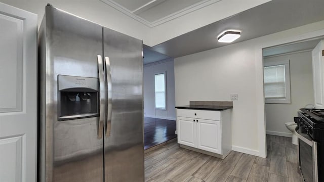 1401 W College Ave, Guthrie, OK 73044 - kitchen with appliances with stainless steel finishes, dark countertops, light wood finished floors, crown molding, and white cabinetry