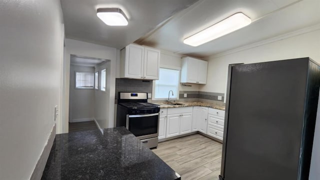 1401 W College Ave, Guthrie, OK 73044 - kitchen with appliances with stainless steel finishes, white cabinets, dark stone counters, light wood-style flooring, and crown molding