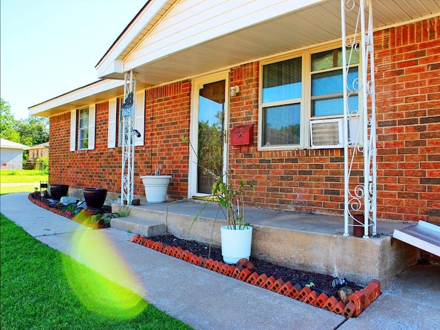 2605 N Kate Ave, Oklahoma City, OK 73111 - doorway to property featuring covered porch, brick siding, and cooling unit