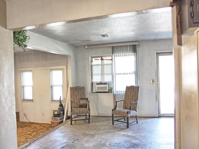 2605 N Kate Ave, Oklahoma City, OK 73111 - sitting room with concrete floors, cooling unit, and a textured ceiling