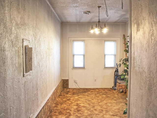 2605 N Kate Ave, Oklahoma City, OK 73111 - unfurnished dining area featuring carpet, a chandelier, and a textured ceiling