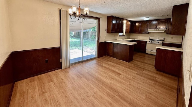 3308 Resh Ct, Norman, OK 73072 - kitchen featuring white range with gas cooktop, light countertops, a chandelier, light wood finished floors, and a textured ceiling
